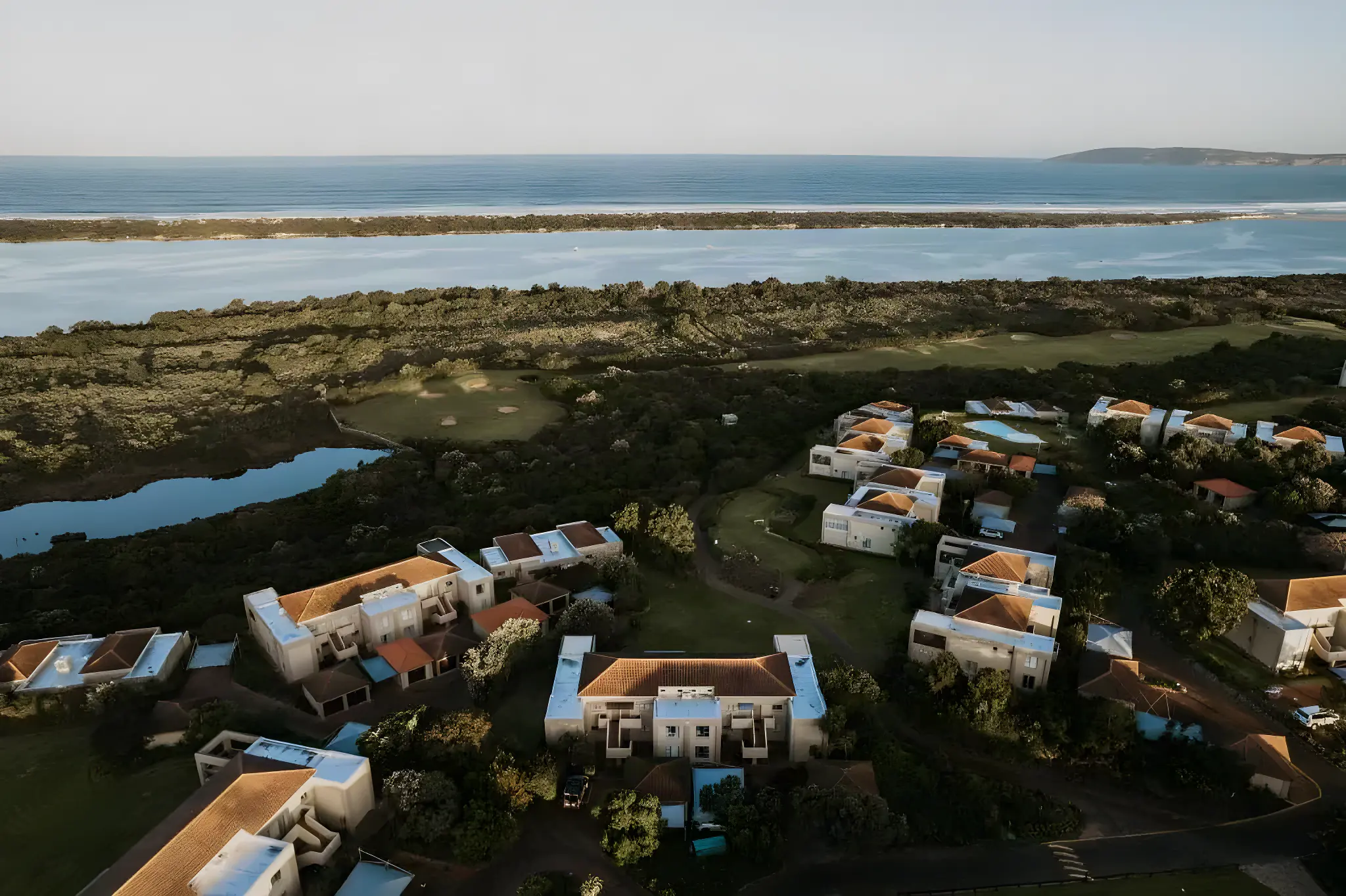 Aerial view of Goose Valley Golf Estate beside the Keurbooms lagoon mouth and open ocean, with golf fairways in between